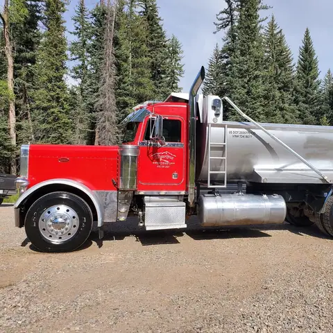 Red semi dump truck with a polished aluminum bed after detailing