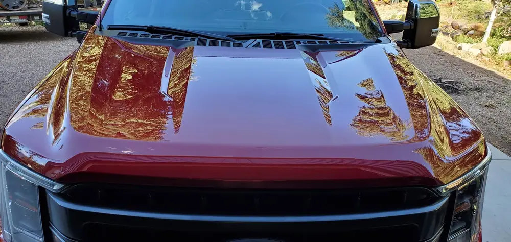 Close-up of the glossy red hood of a Ford F-150 after detailing