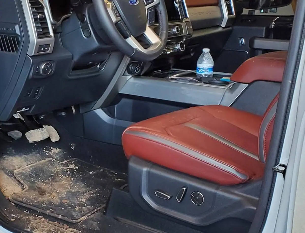 Before: mud and debris caked on a Ford F-150 driver floor and mats